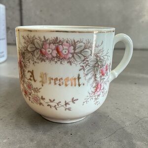 Antique or vintage collectible souvenir teacup featuring a floral pattern